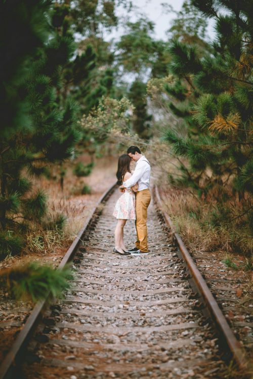 a couple hugging on the train track